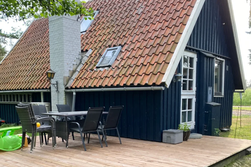 Havemøbelsæt placeret på den nyrenoverede 25 m² træterrasse i brunimprægneret fyr ved sommerhus i Vordingborg.